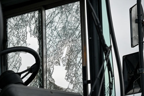A damaged bus with a shattered window after a collision illustrating the types of cases a Concord bus accident lawyer handles.