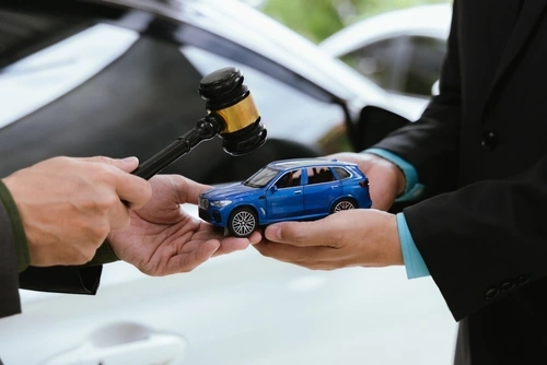 Lawyers with a gavel and a model car discuss winning car accident claims.