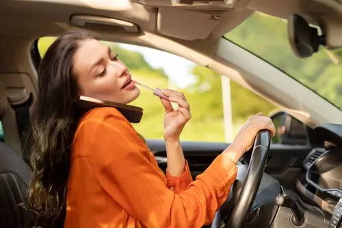 Woman Putting On Lip Gloss While Driving